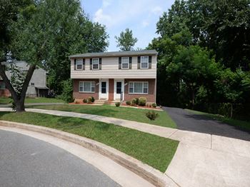 a house with a tree in front of it at Rockdale Gardens Apartments*, Baltimore, MD, 21244